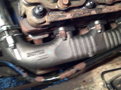 1993 Ford F-150 - A close-up view of an engine's exhaust manifold, showing some stamped part numbers.