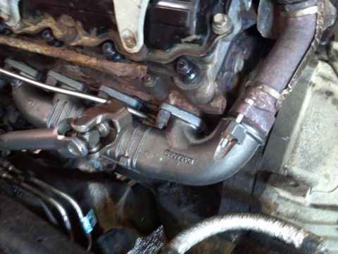 1993 Ford F-150 - Close-up view of an engine's exhaust manifold, showing mechanical components and signs of wear.