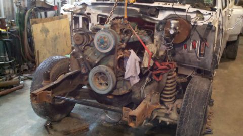 1993 Ford F-350 - The engine is being hoisted out of a disassembled truck in a workshop setting.