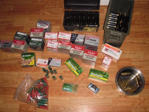 1993 Ford Bronco - A collection of ammunition boxes and cans are displayed on a wooden floor, brands like Federal, Winchester, and Remington.