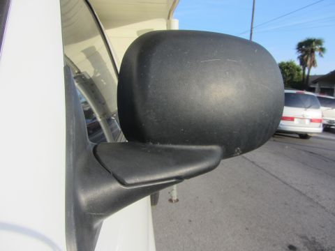 1968 Ford Mustang - Side mirror on a white vehicle. Other vehicles are parked on the street in the background.