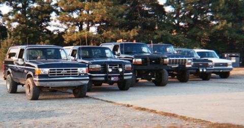 1988 Ford Bronco - A lineup of Ford Broncos and F-Series trucks, with the lead vehicle appearing to be a late 1980s model.