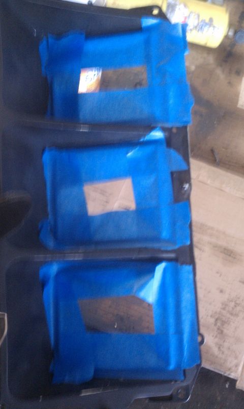 1978 Ford Bronco - A dark dashboard panel features three rectangular openings covered with blue tape and small labels.