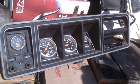 1978 Ford Bronco - A close-up of a vehicle's gauge cluster, a speedometer and fuel gauge, is shown against a background of boxes.