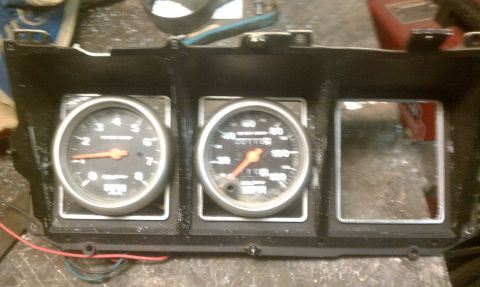 1978 Ford Bronco - A dashboard gauge cluster is shown, a tachometer and speedometer with orange needles.