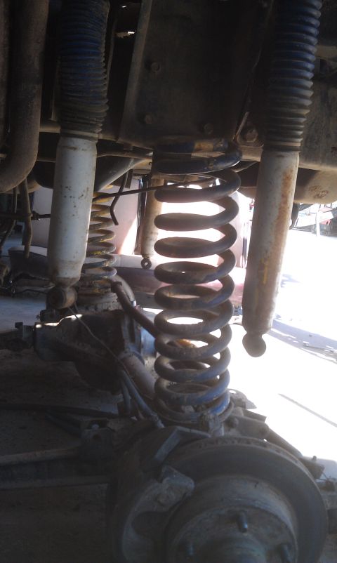 1978 Ford Bronco - The image shows the front suspension system of a vehicle, including coil springs and shock absorbers.