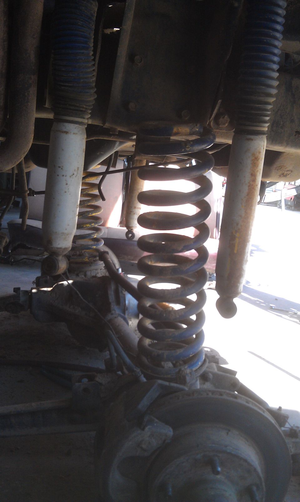 Close-up of front suspension with coil springs and shock absorbers