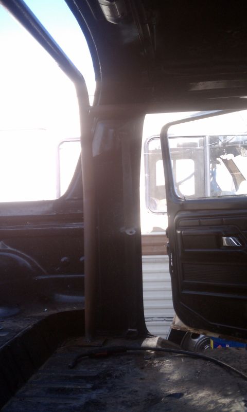 1978 Ford Bronco - The interior of a vehicle is visible, focusing on the roll cage structure and door.