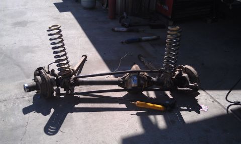 1978 Ford Bronco - Front axle assembly with coil springs and a yellow shock absorber, likely for an off-road vehicle.