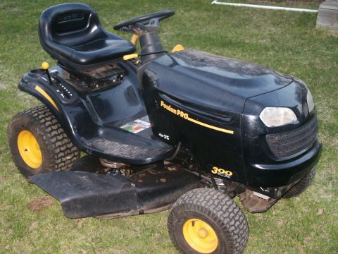 1966 Ford Bronco - A black Poulan Pro riding lawn mower with yellow accents is parked on a grassy lawn.