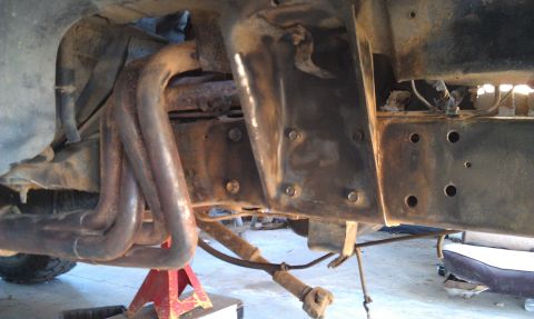 1978 Ford Bronco - Underside view of a 1978 Ford Bronco frame, showing exhaust components and a seat.