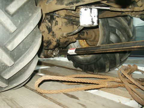 1966 Ford Bronco - Close-up view of a tractor's undercarriage, including the oil filter and drive axle.
