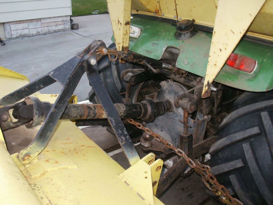 Tractor rear hitch with yellow and green body panels