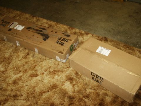 1966 Ford Bronco - Two "ESTATE RAKE" boxes are shown on a carpeted surface, with one box showing some oil stains.