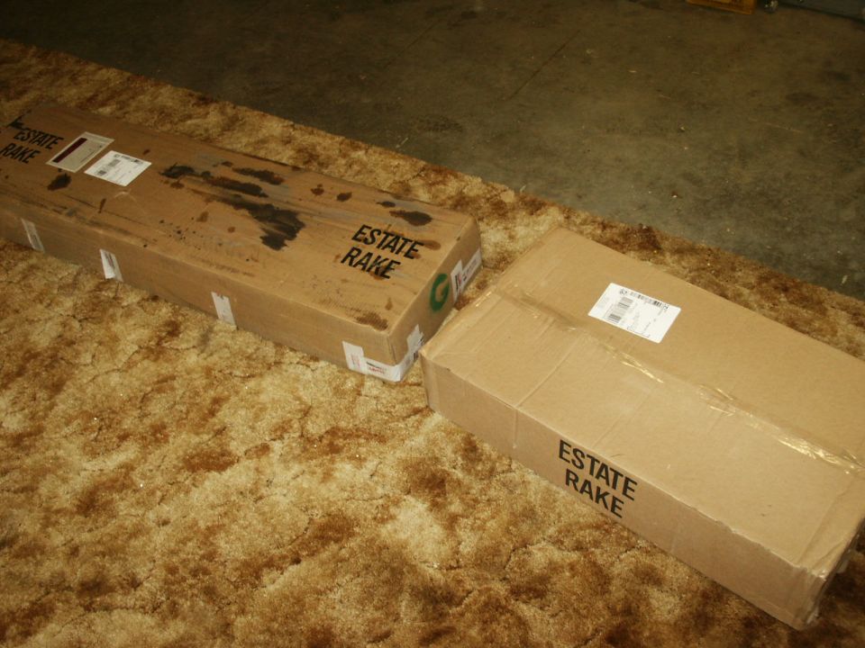 Two "ESTATE RAKE" boxes on a carpeted floor