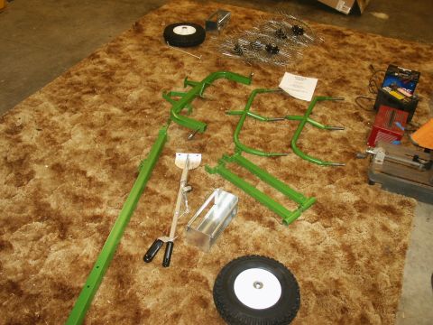 1966 Ford Bronco - Various parts for what appears to be agricultural equipment are spread out on a carpeted floor.