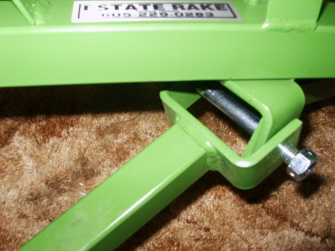 1966 Ford Bronco - A close-up view of a green metal rake part, a label that reads 'ESTATE RAKE' and a phone number.