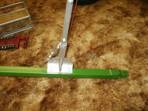 1966 Ford Bronco - A green metal bar with a silver mechanical assembly and a red tool are on a brown carpet.