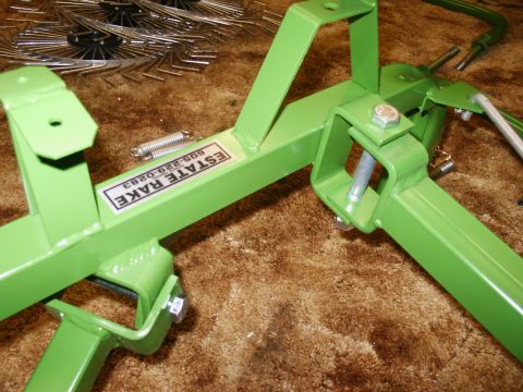 1966 Ford Bronco - Close-up of a green estate rake assembly, showing springs and bolts. Text label identifies the part.