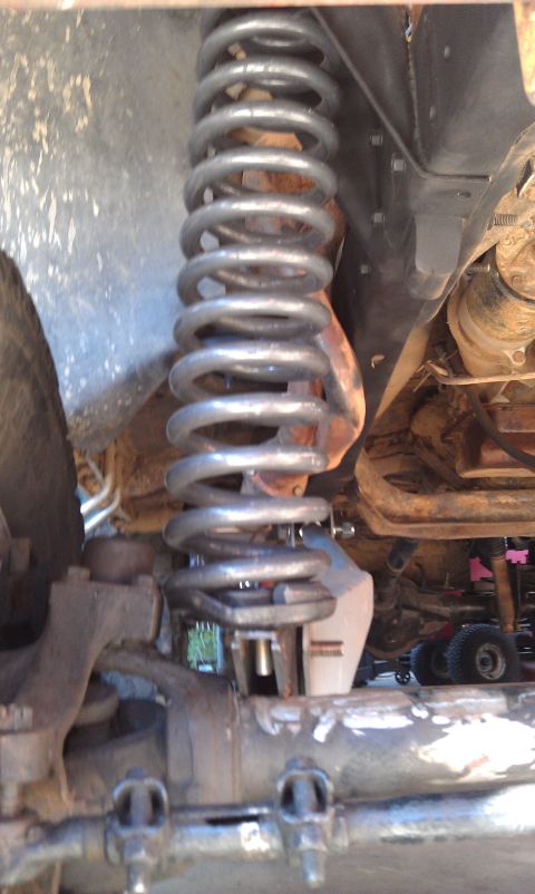1978 Ford Bronco - This photo shows a close-up view of a vehicle's front suspension system, focusing on the coil spring and related parts.