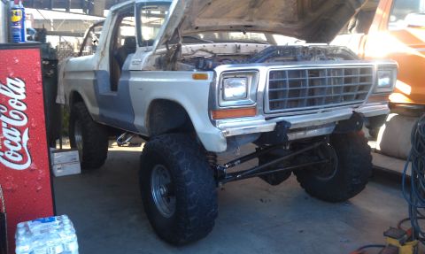 1978 Ford Bronco - Front view of a 1978 Ford Bronco undergoing modifications, showing its lifted suspension.