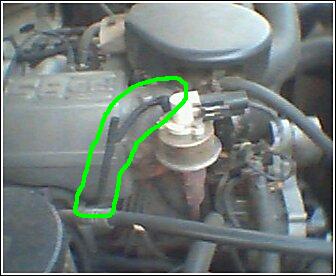 1992 Ford Bronco - Detail of a Ford engine component, likely part of the fuel system, highlighted with a green line.