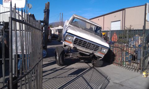 1978 Ford Bronco - A white 1978 Ford Bronco is shown with its front end lifted at an angle, partially obscured by a fence.