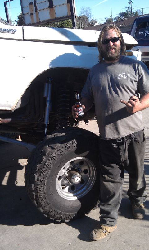1978 Ford Bronco - A man poses with a lifted 1978 Ford Bronco, its off-road modifications.