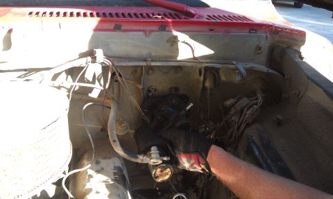 1978 Ford Bronco - Close-up of engine bay components, likely brake booster assembly, during maintenance or repair.
