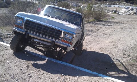 1978 Ford Bronco - A white 1979 Ford F-Series truck is shown off-road with its front wheels at an angle.
