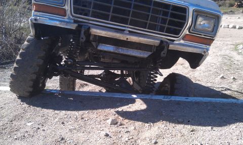 1978 Ford Bronco - This lifted truck is stuck on a concrete barrier, showing off its suspension and off-road tires.