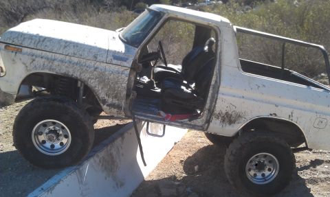 1978 Ford Bronco - This 1978 Ford Bronco is shown off-road with its doors open and mud on the tires.