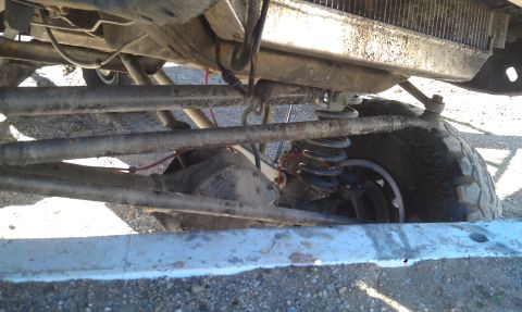 1978 Ford Bronco - Close-up of a vehicle's undercarriage, focusing on the suspension and tire assembly.