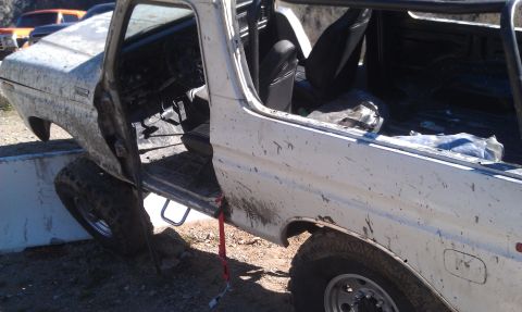 1978 Ford Bronco - This off-road vehicle is positioned precariously with its tires resting on a concrete barrier.