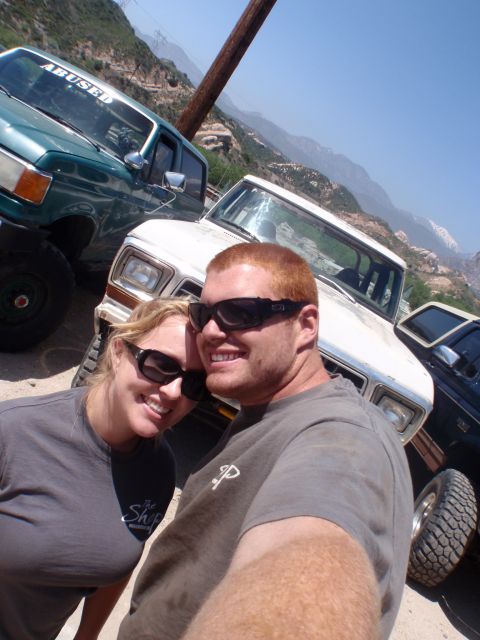 1978 Ford Bronco - A couple poses for a selfie in front of a 1978 Ford Bronco, with other off-road vehicles visible.