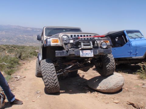 1978 Ford Bronco - Two Jeeps navigate a rocky trail under a clear blue sky.