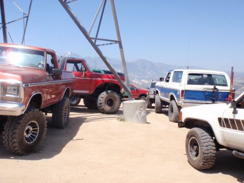 1978 Ford Bronco - A group of off-road vehicles, including a 1978 Ford Bronco, gathered on a scenic overlook.