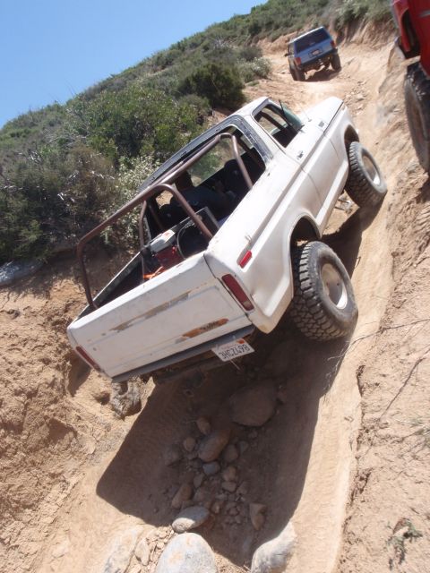 1978 Ford Bronco - White 1978 Ford Bronco navigates a steep off-road trail with another vehicle following.