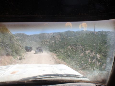 1978 Ford Bronco - Two vehicles navigate a dusty, mountainous terrain on a sunny day.