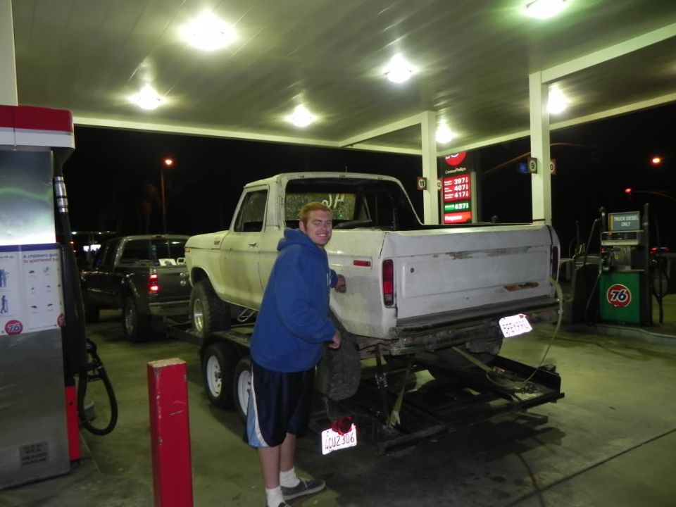 White 1978-1979 Ford F-Series pickup truck rear view on trailer at gas station
