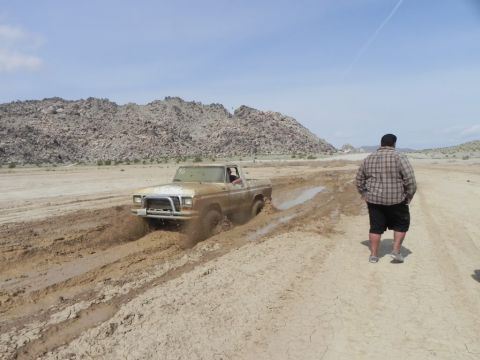 1978 Ford Bronco - Ford pickup truck stuck in mud in a desert landscape.