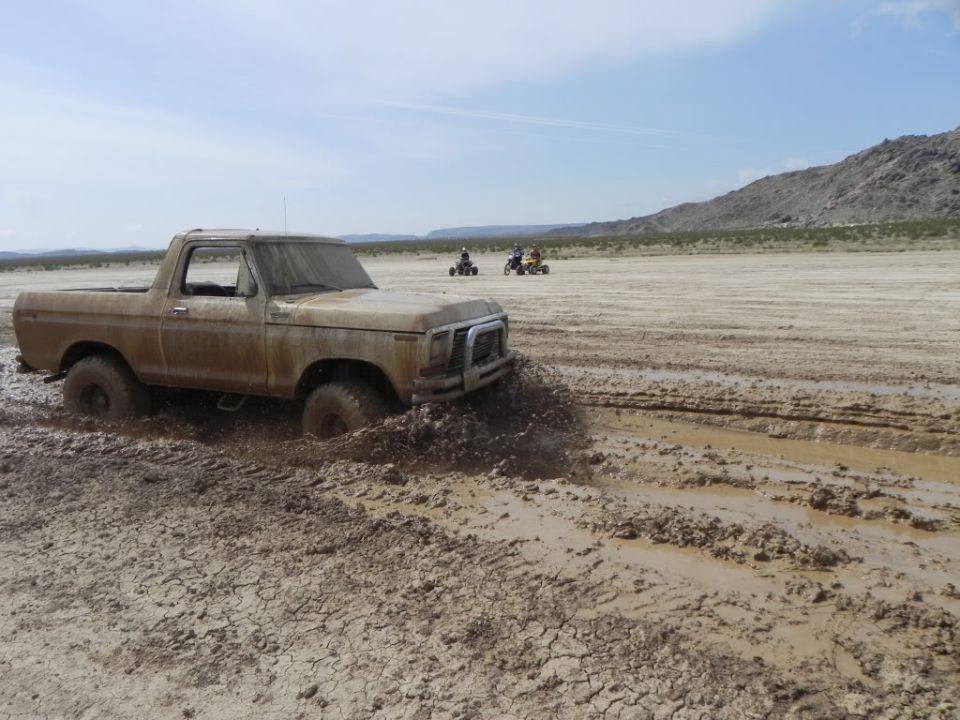 1978 Ford Bronco stuck in mud, front right wheel deep in mire