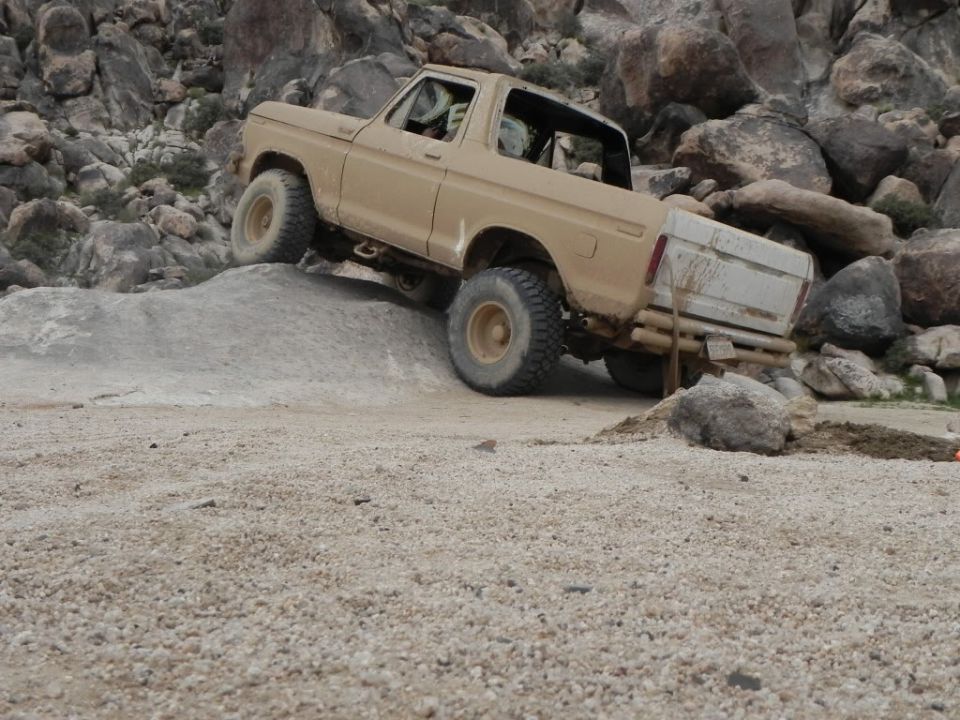 Tan 1978 Ford Bronco climbing rocky terrain