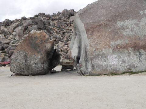 1978 Ford Bronco - A tan SUV is positioned between two massive boulders in a rocky, outdoor landscape.