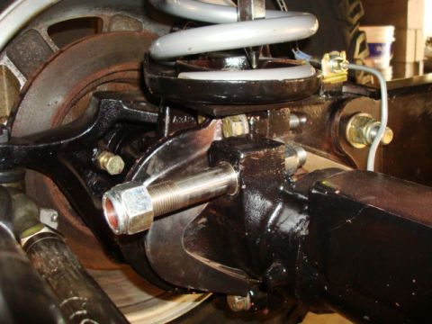1995 Ford Bronco - Close-up of a vehicle's suspension system, focusing on a painted metal component and a coil spring.