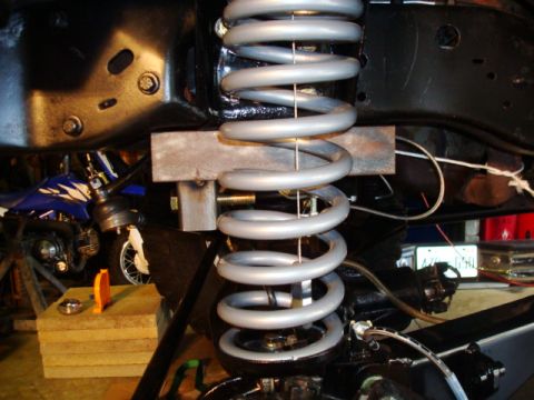 1995 Ford Bronco - This image shows a close-up of a vehicle's suspension system, focusing on the coil spring and its components.