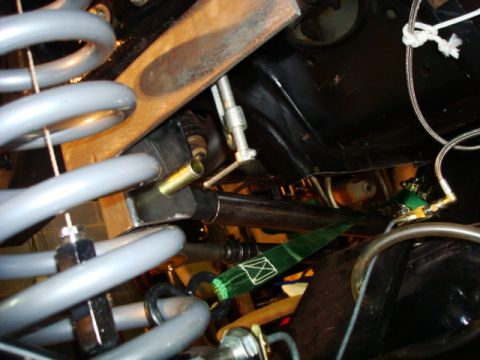 1995 Ford Bronco - Undercarriage view of vehicle steering linkage components, including springs and a metal bracket.
