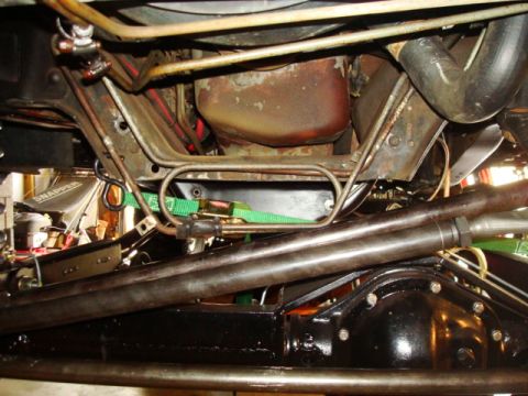 1995 Ford Bronco - Undercarriage view of steering linkage and suspension components, including tie rods and a differential housing, secured with a green strap.