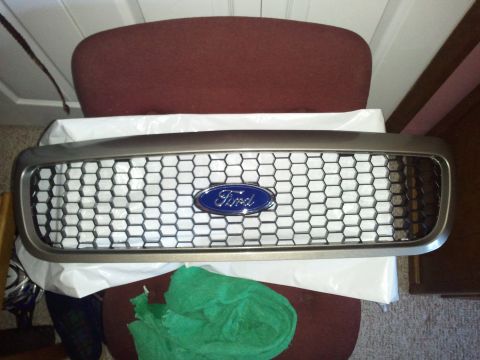 2007 Ford Crown Victoria - A Ford emblem is centered on a honeycomb grille, likely a replacement part.