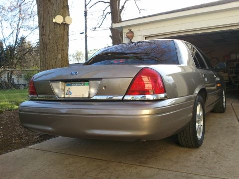 2007 Ford Crown Victoria - Rear view of a tan 2007 Ford Crown Victoria parked in a driveway.